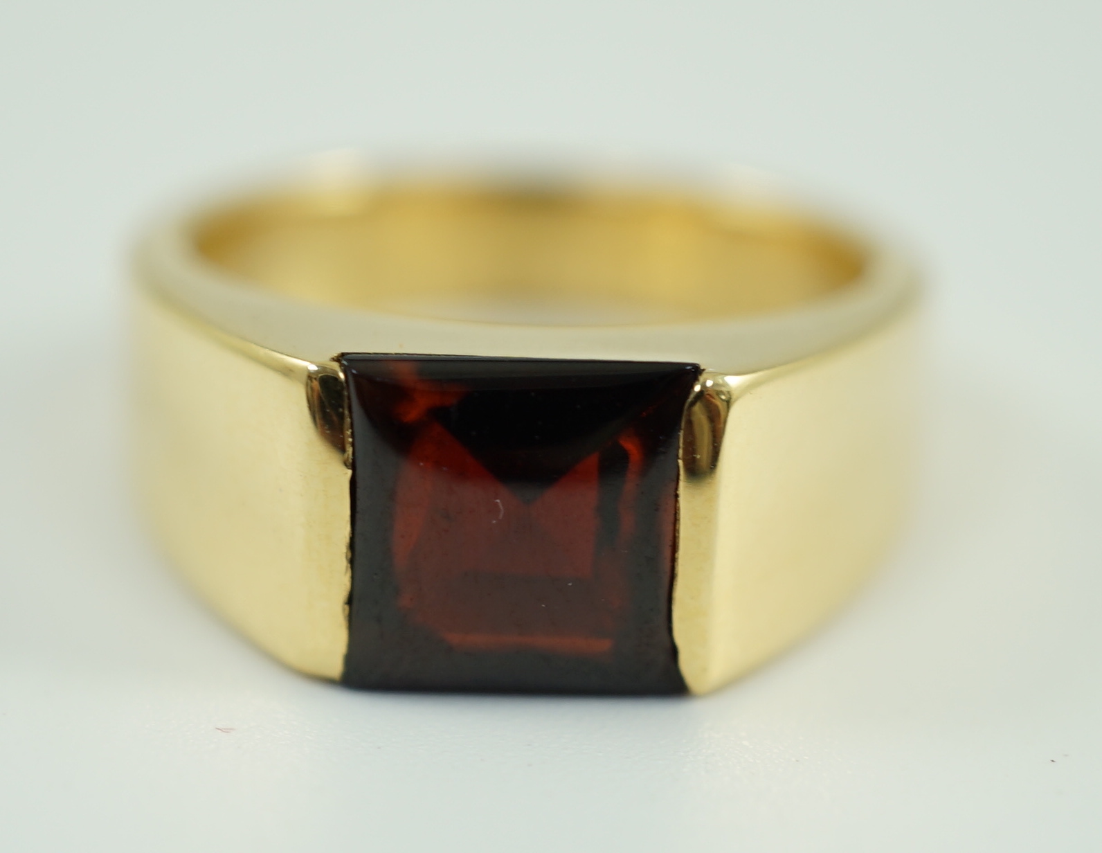 A gentleman's 1990's Cartier 18ct gold and gypsy set garnet ring